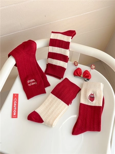 Detail of red and beige cashmere blend socks with cat embroidery and striped patterns