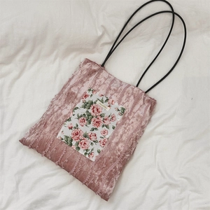 Vue détaillée du cabas en velours vieux rose avec patch floral et bordure dentelle