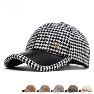 Houndstooth baseball cap with black leather brim and metal M logo, multi-color palette