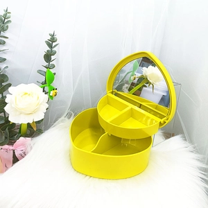 Dettaglio del portagioie giallo a forma di cuore con specchio interno e scomparti