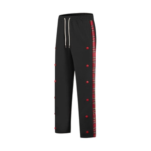 Detail view of men's black joggers featuring plaid side stripes and snap button closures