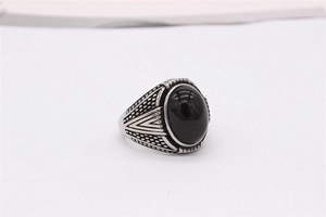 Détail d'une bague vintage en acier pour homme avec pierre noire ovale et textures