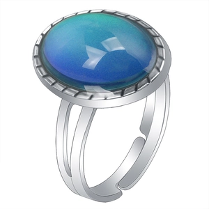 Adjustable silver color metal ring with oval color-changing gemstone on white background