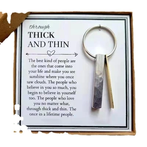 Golden and silver bar keychains in a gift box with a friendship message card