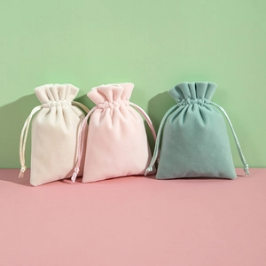 Three plush drawstring pouches in beige pink and green for jewelry storage and gifts