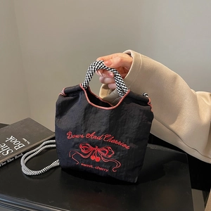 Black nylon handbag with red cherry and bow embroidery featuring checkerboard handles