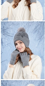Detail of grey winter knit hat with fur pompom and matching touchscreen gloves set
