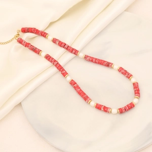 Detail of red stone and white pearl necklace with golden clasp on silk background