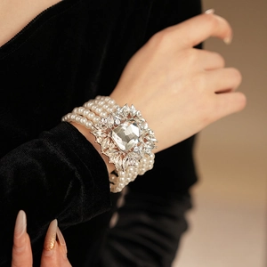 Detail of multi-layer pearl bracelet featuring a large square crystal centerpiece