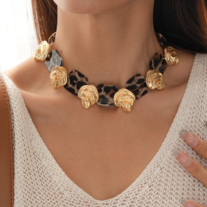 Close-up of vintage resin leopard print necklace with gold swirl texture detail