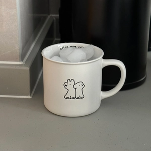 Close-up of white ceramic dog mug with cartoon print and Drink More Water interior text