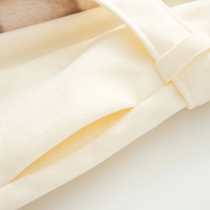 Detailed macro view of cream wool coat fabric with side pocket and stitching quality