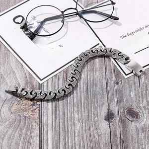 Detailed view of vintage silver S-link chain bracelet on rustic wood background