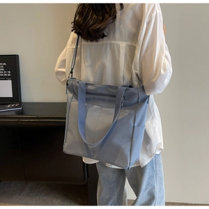 Detail shot of light blue large capacity nylon tote bag with durable shoulder straps