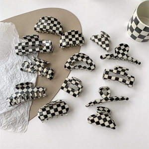 Flat lay of multiple black and white checkerboard hair claws in various geometric shapes
