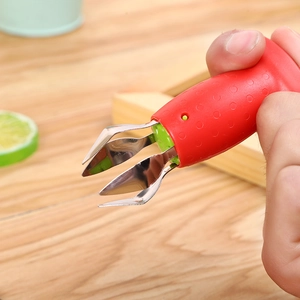 Detailed macro view of the stainless steel strawberry huller tool with a red non-slip handle