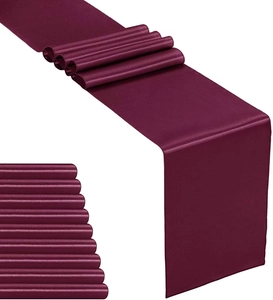 Detail of burgundy satin table runner showing silky texture and smooth fabric drape