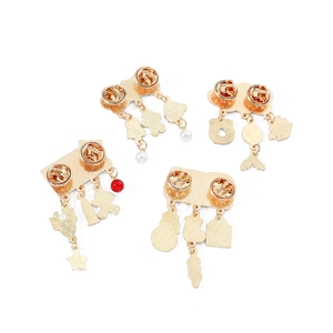 Detailed view of gold metal pins featuring white pearls, stars, and leaves pendants
