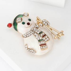 Broche bonhomme de neige en émail blanc avec strass colorés et bâtons de ski dorés
