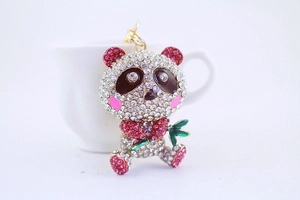 Detailed close-up of a metal panda keychain with pink and white rhinestones holding bamboo