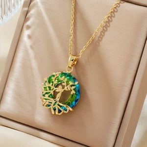 Macro shot of gold Tree of Life pendant with gradient crystal in a jewelry box