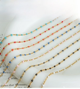 Detailed macro view of delicate 18K gold plated chains with multi-colored enamel beads