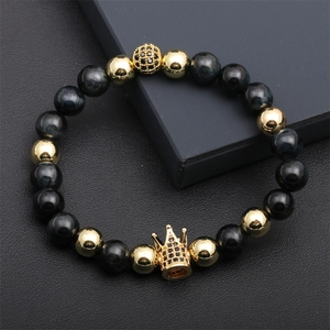 Detailed macro view of men's crown bead bracelet with tiger eye stones and gold accents