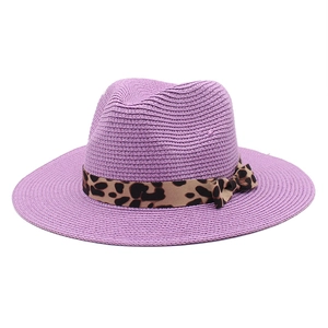 Detail of purple straw Panama hat with leopard print ribbon and tight woven texture