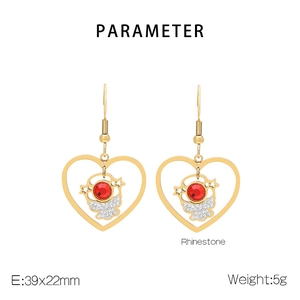 Detail view of heart-shaped gold earrings with red stones and rhinestone parameters