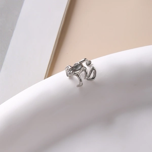 Vue macro d'un earcuff grenouille argenté avec texture métallique sur base céramique