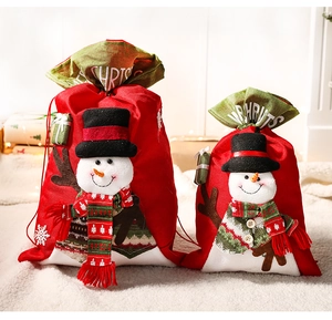Detail view of large and small red fabric Christmas gift bags with 3D snowman decorations