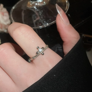 Close-up of vintage silver cross ring with sparkling zircon stone worn on finger