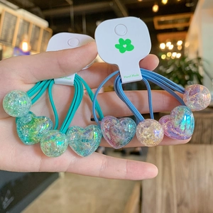 Detailed view of elastic hair ties featuring iridescent resin hearts and beads in green and blue