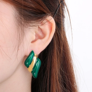 Détail de boucles d'oreilles plaquées or 18K ondulées avec émail vert
