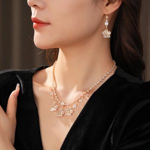 Detail of luxury zircon flower pendant necklace and earrings set worn by a model