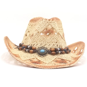 Macro shot of a breathable straw cowboy hat with a beaded turquoise metal buckle trim