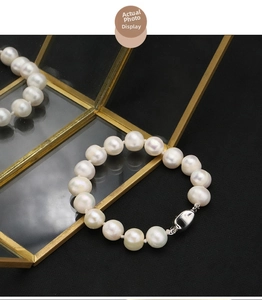 Macro detail of natural pearl bracelet with 18k gold plating on elegant black texture