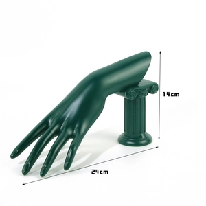 Macro detail of dark green hand sculpture jewelry stand with classical Roman column base