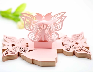 Detail of pink laser-cut butterfly wedding favor box with pearl paper and ribbon