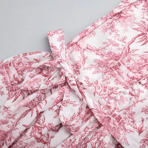 Détail de l'imprimé Toile de Jouy rouge sur robe blanche avec boutons et nœud