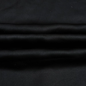 Vue détaillée de la texture du tissu noir soyeux avec drapés souples et éclat subtil
