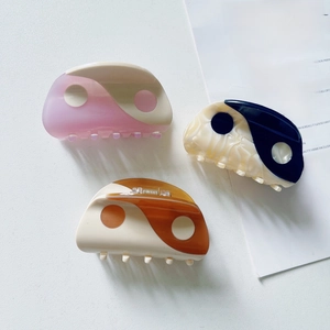 Yin Yang acetate hair claws in pink, marble black and brown colors on white background