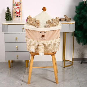 Detail of Christmas reindeer chair cover with golden antlers and snowflake scarf on chair