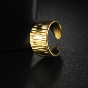 18K gold plated wide band geometric stainless steel ring with textured finish on black backdrop