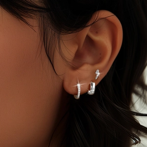 Close-up of S925 sterling silver hoop set with lightning bolt stud and pavé crystals