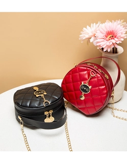 Detail of round quilted leather mini bags with cat charms and gold chain straps