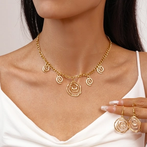 Detailed close-up of golden spiral swirl pendant necklace and matching earrings set