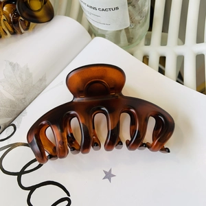 Detailed close-up of large tortoiseshell hair claw clip with glossy finish and metal spring