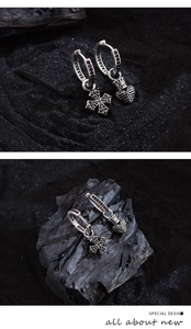 Detail of silver asymmetric earrings with black zircon cross and crown heart charms