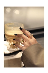Detailed shot of a gold butterfly ring and a minimalist stone ring on a hand
